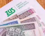Koperta ZUS z banknotami 100, 200 i 500 zł. Nadzieja na dodatkowe środki, być może 13. emerytury.