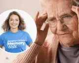 Kobieta z bólem głowy, być może objawy alzheimera. Obok uśmiechnięta wolontariuszka Alzheimer's Society Memory Walk.