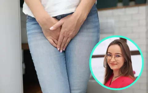 Kobieta w dżinsach, z dłońmi na kroku, w tle kobieta w okularach. Temat: sikanie podczas sexu.