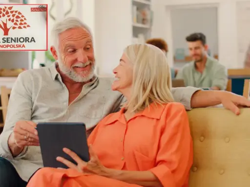 Uśmiechnięci seniorzy przeglądają tablet, obok nich logo "Karta Seniora Ogólnopolska", sugerujące zniżki w aptece.