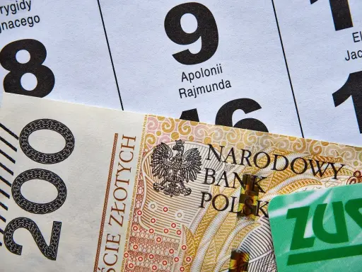 Zastanawiasz się, jakie dokumenty do ZUS na emeryturę? Na zdjęciu polskie banknoty i kalendarz z datami.