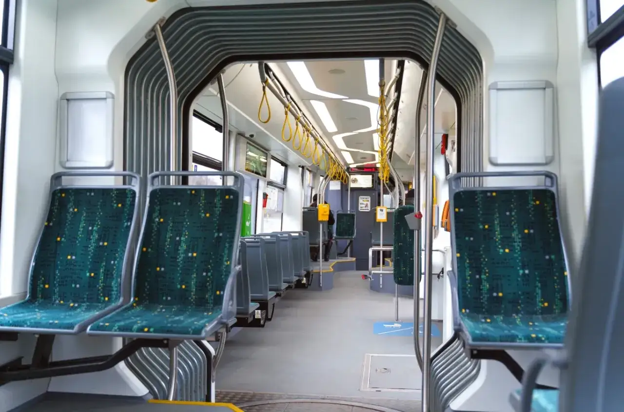 Wnętrze tramwaju z zielonymi siedzeniami. Idealne miejsce na darmowe przejazdy MPK dla emerytów, by zwiedzać miasto.